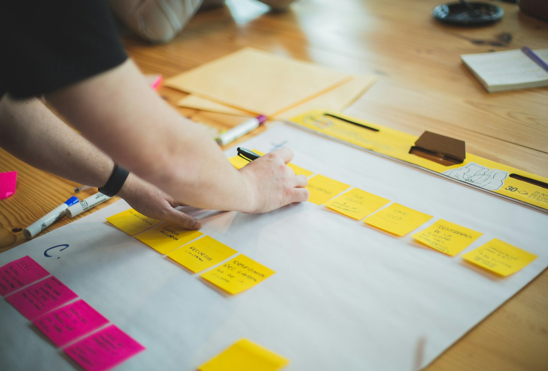Hands arranging ideas and audience notes across a campaign planning desk.