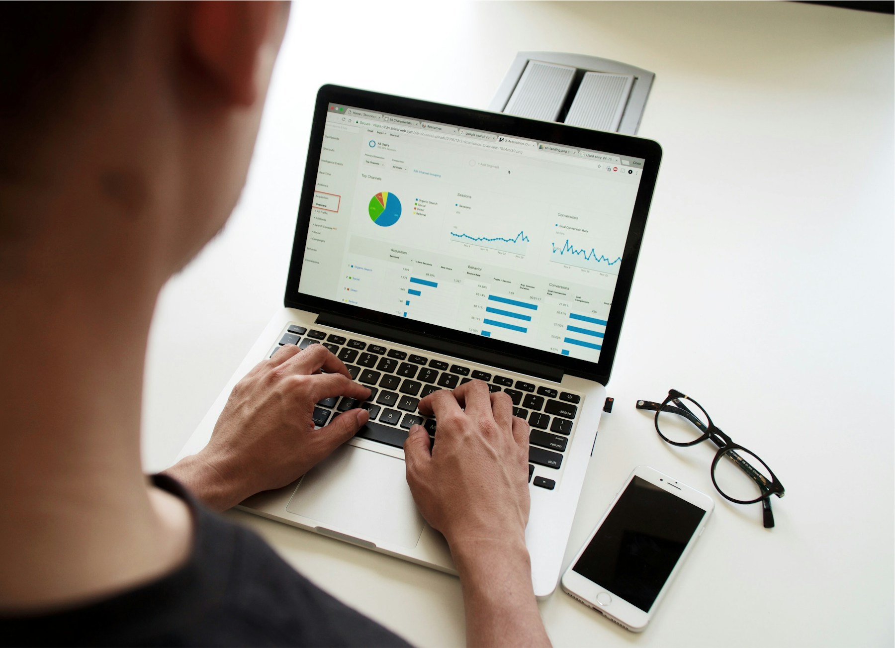 A business professional reviewing performance charts on a laptop at a desk.
