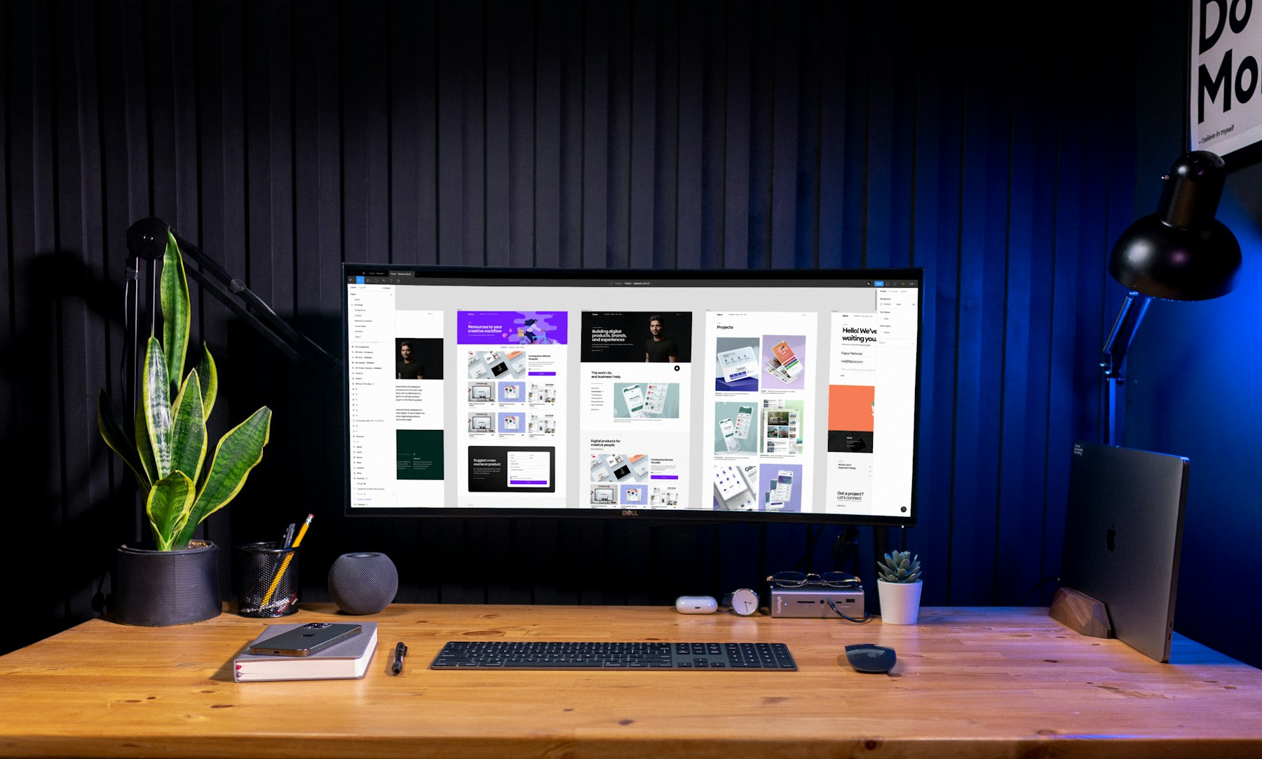 A designer’s workspace with website layouts on a large monitor