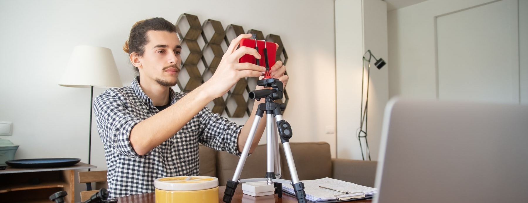 An adult creator prepares a camera and laptop for a home-studio recording